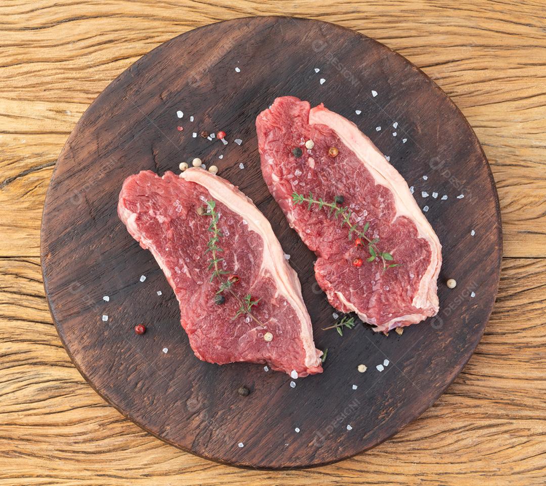 Fatias de lombo de tira crua sobre tábua de madeira com temperos