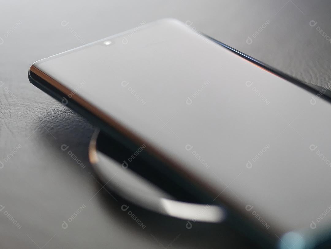 Vista próxima do celular sendo carregado sem fio com foco seletivo.