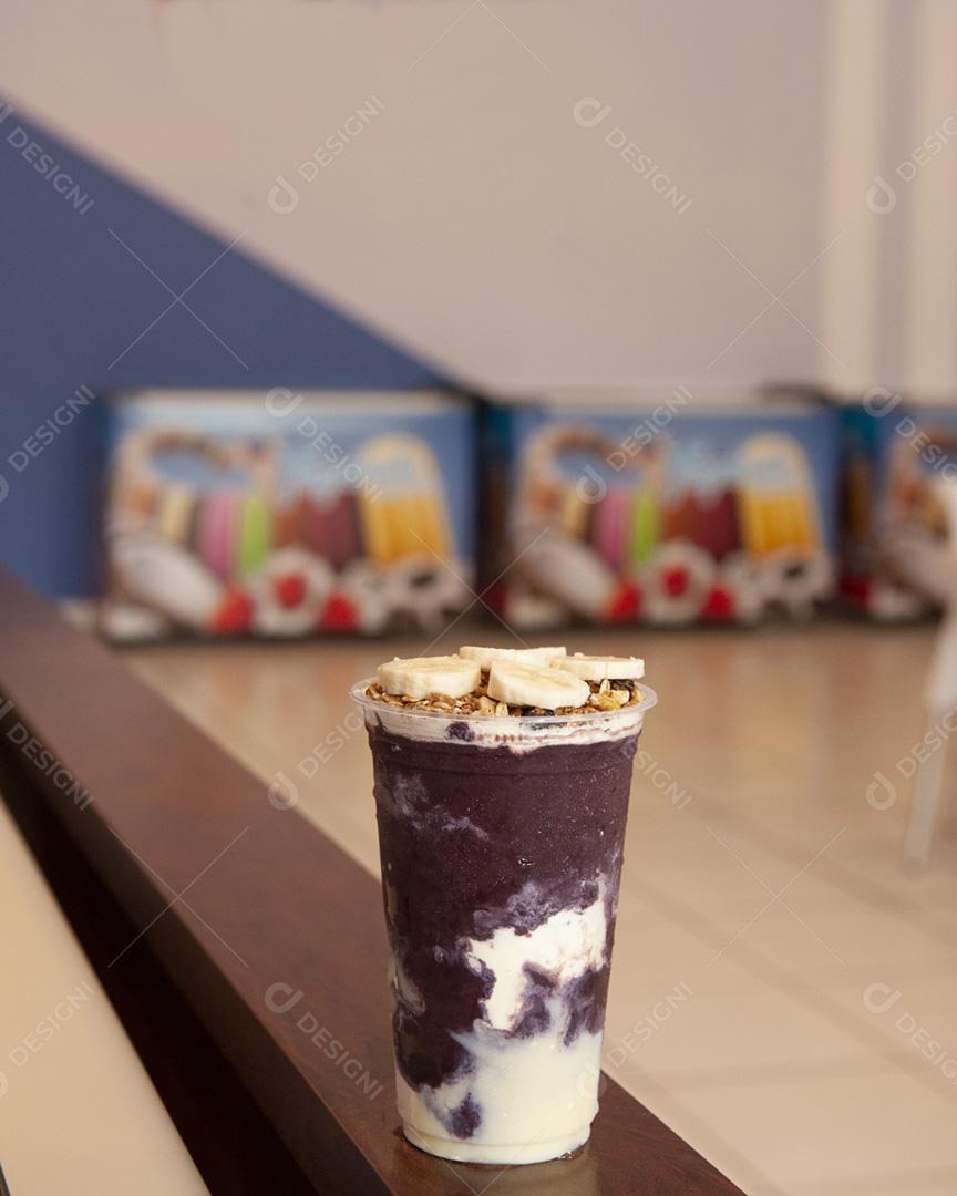 Taça de sorvete de açaí com banana e granola em cima do sorvete