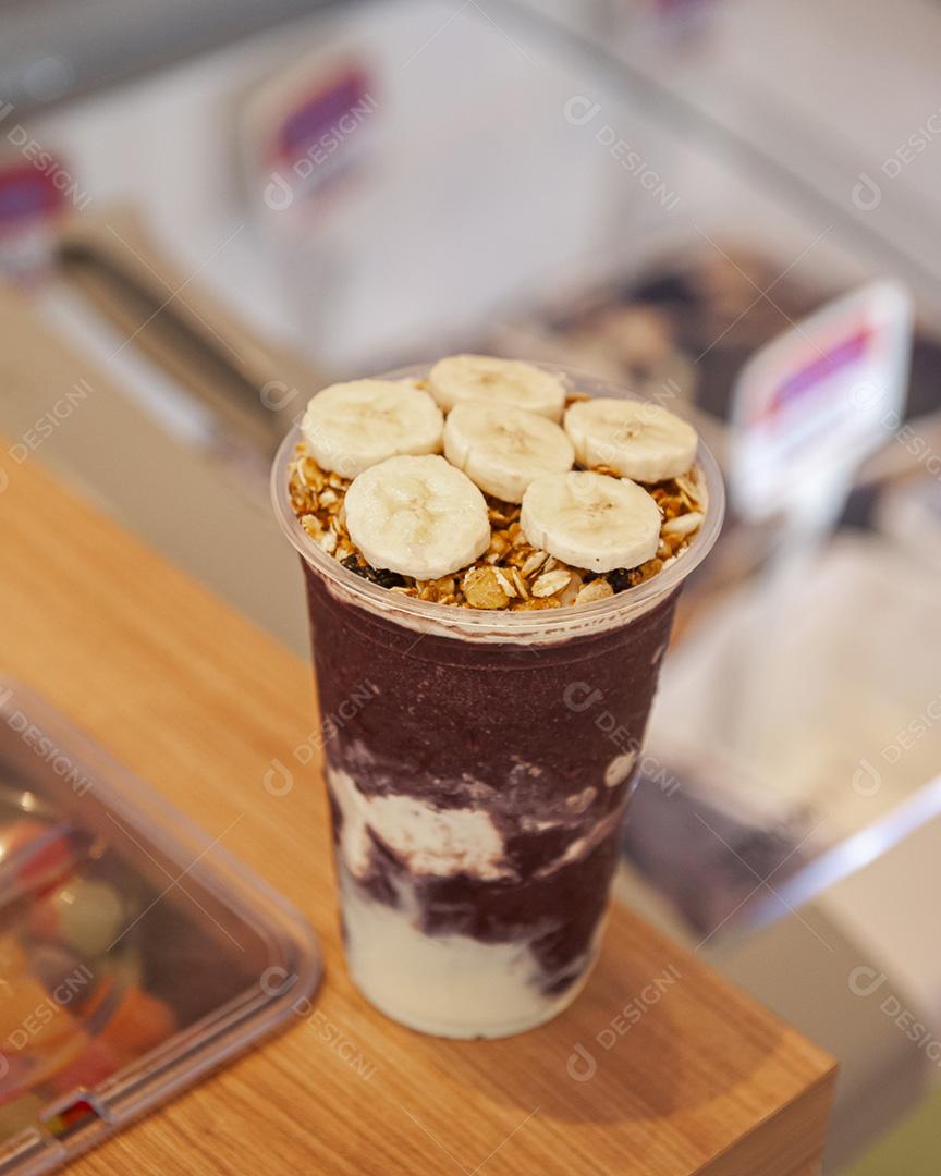 Taça de sorvete de açaí com banana e granola em cima do sorvete