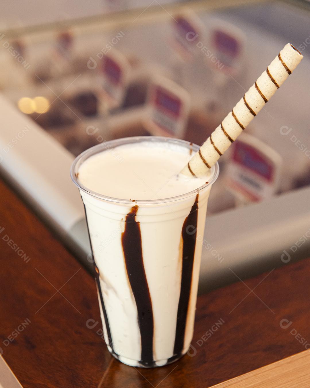 Copo plástico de milk-shake de baunilha com chocolate em cima do gelo