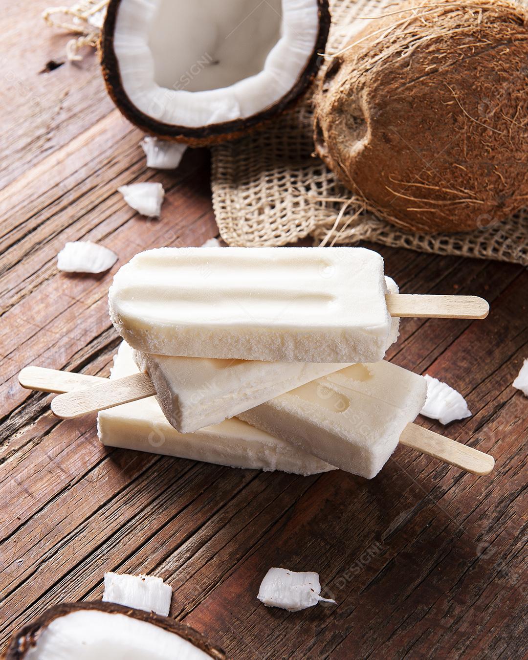 Picolés de coco em fundo rústico com coco fresco