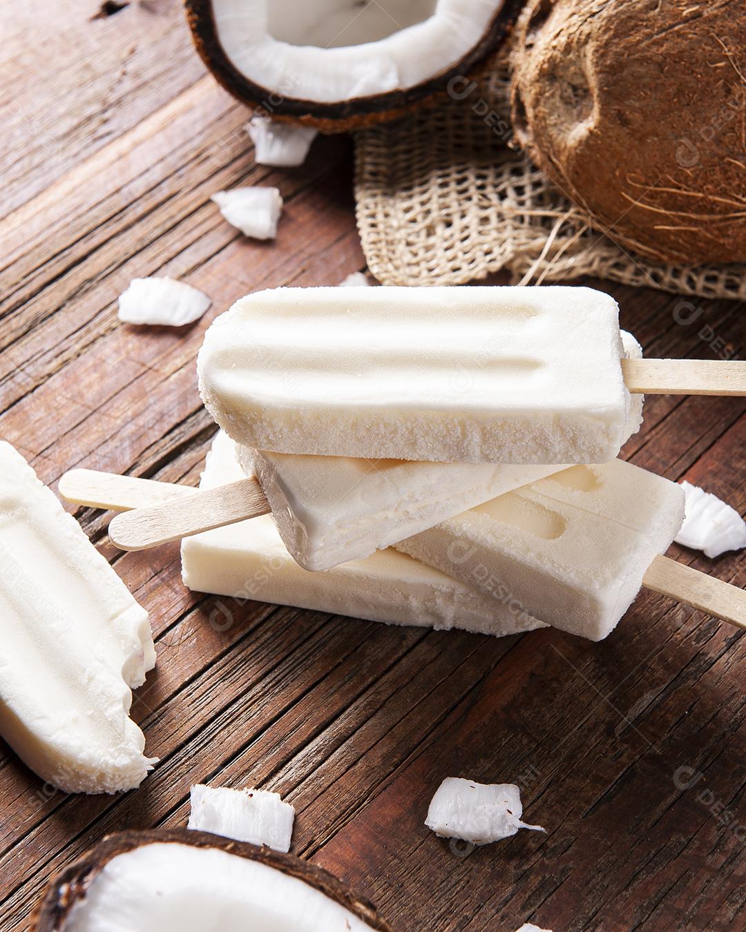 Coconut popsicles on rustic background with fresh coconut