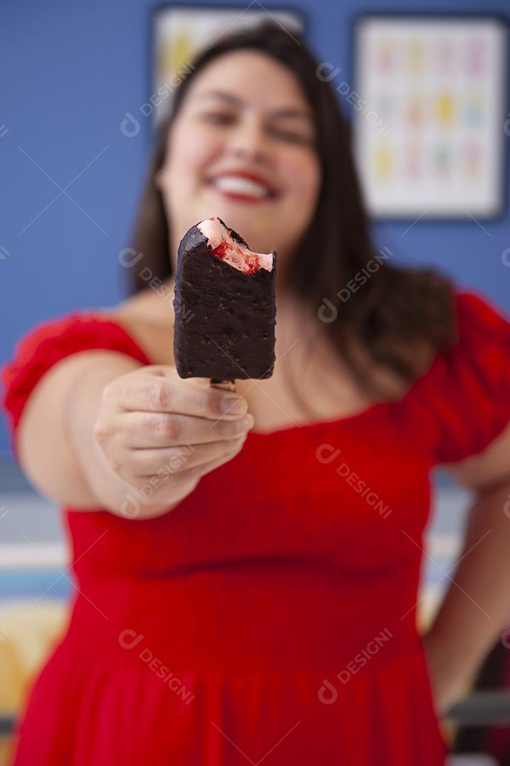 Linda senhora protegida de picolé de morango com cobertura de chocolate.