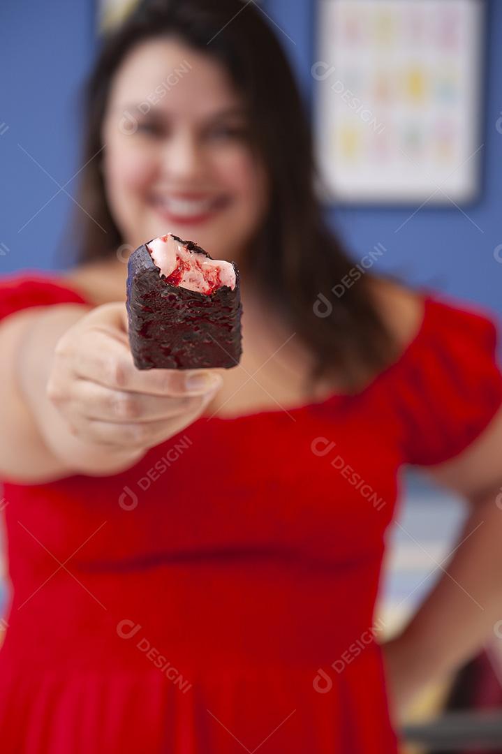 Linda senhora protegida de picolé de morango com cobertura de chocolate.