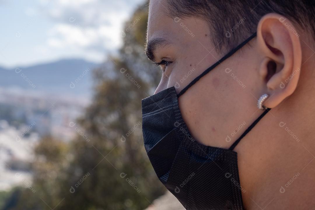 Vista próxima do homem usando máscara facial com a cidade de Málaga ao fundo.