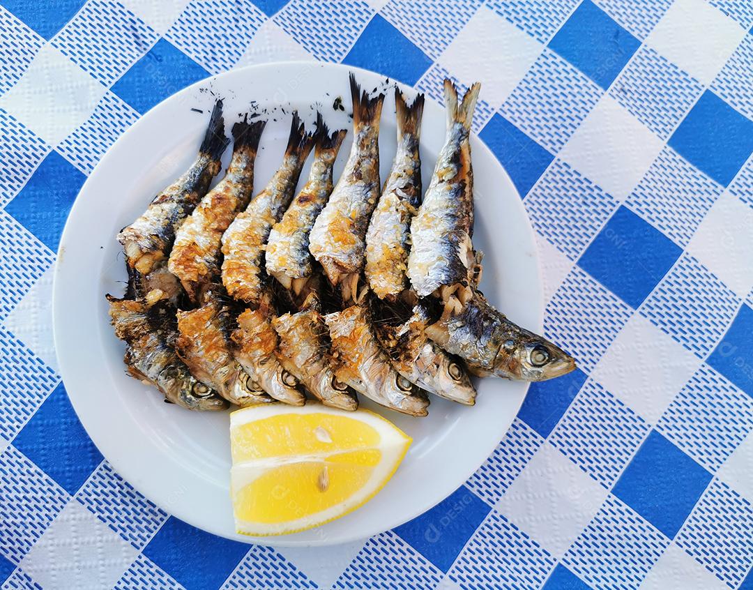 Vista de um típico espeto de sardinha no prato.