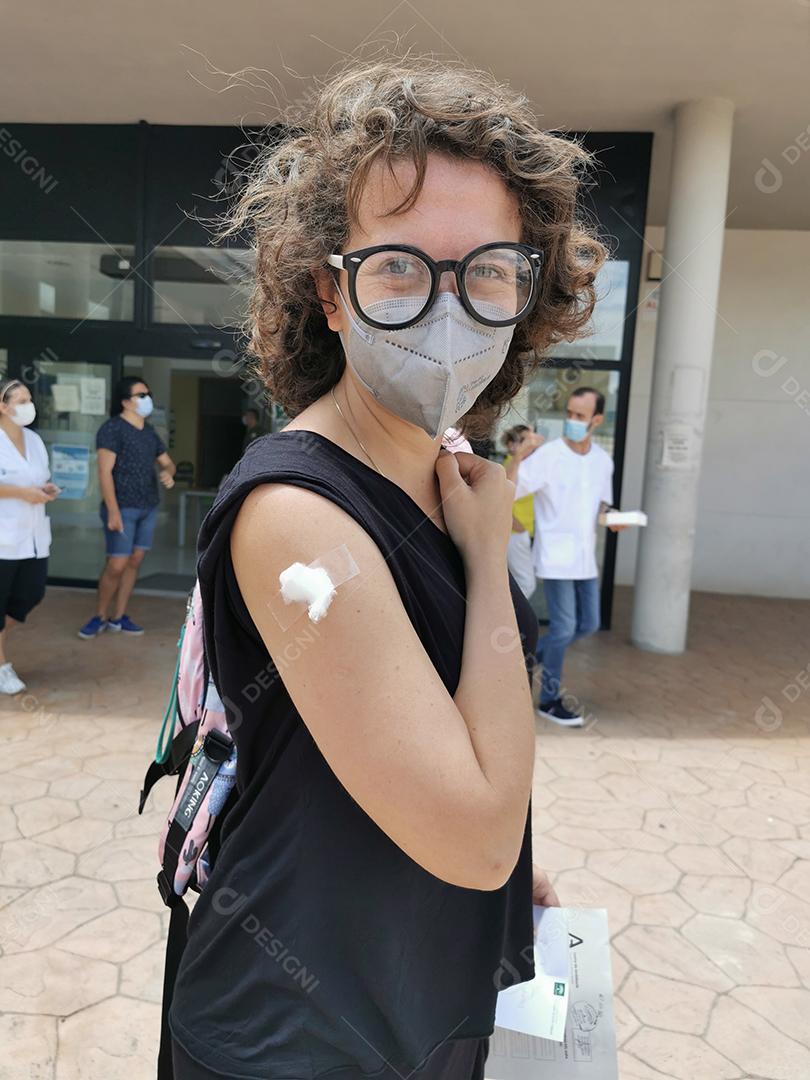 Jovem mostrando o braço logo após receber a vacina covid no centro de saúde.