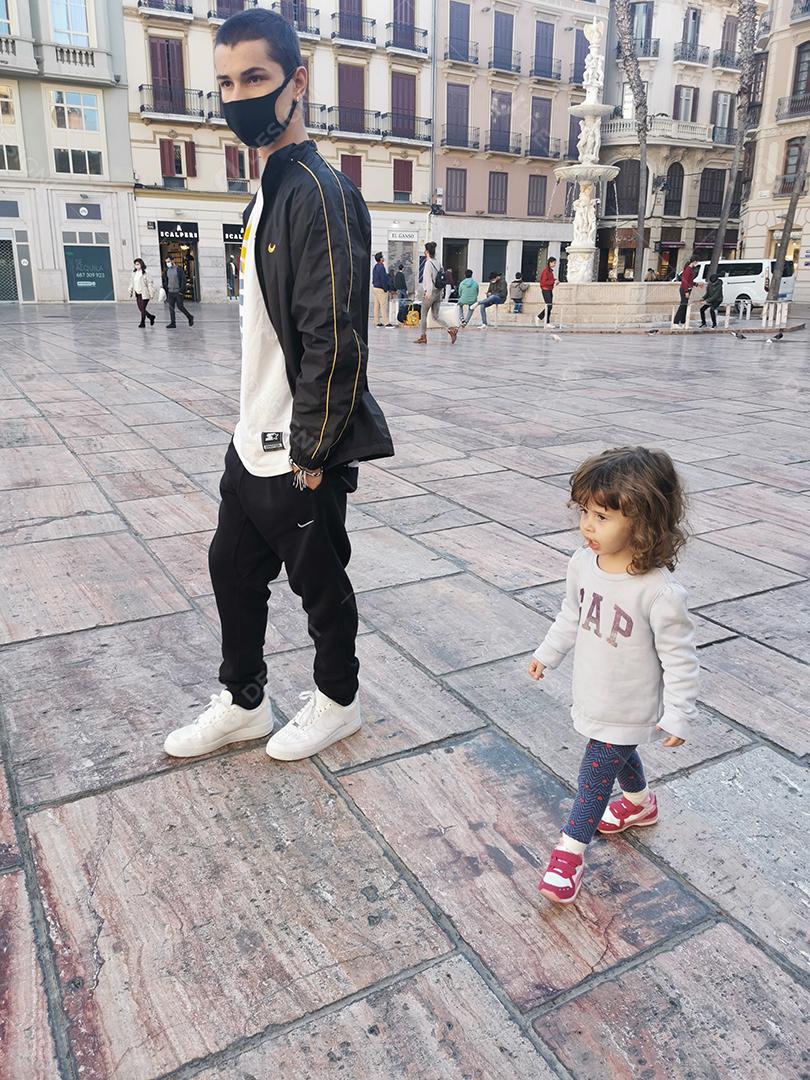 Vista de irmão e irmã caminhando pelo centro de Málaga durante a pandemia.