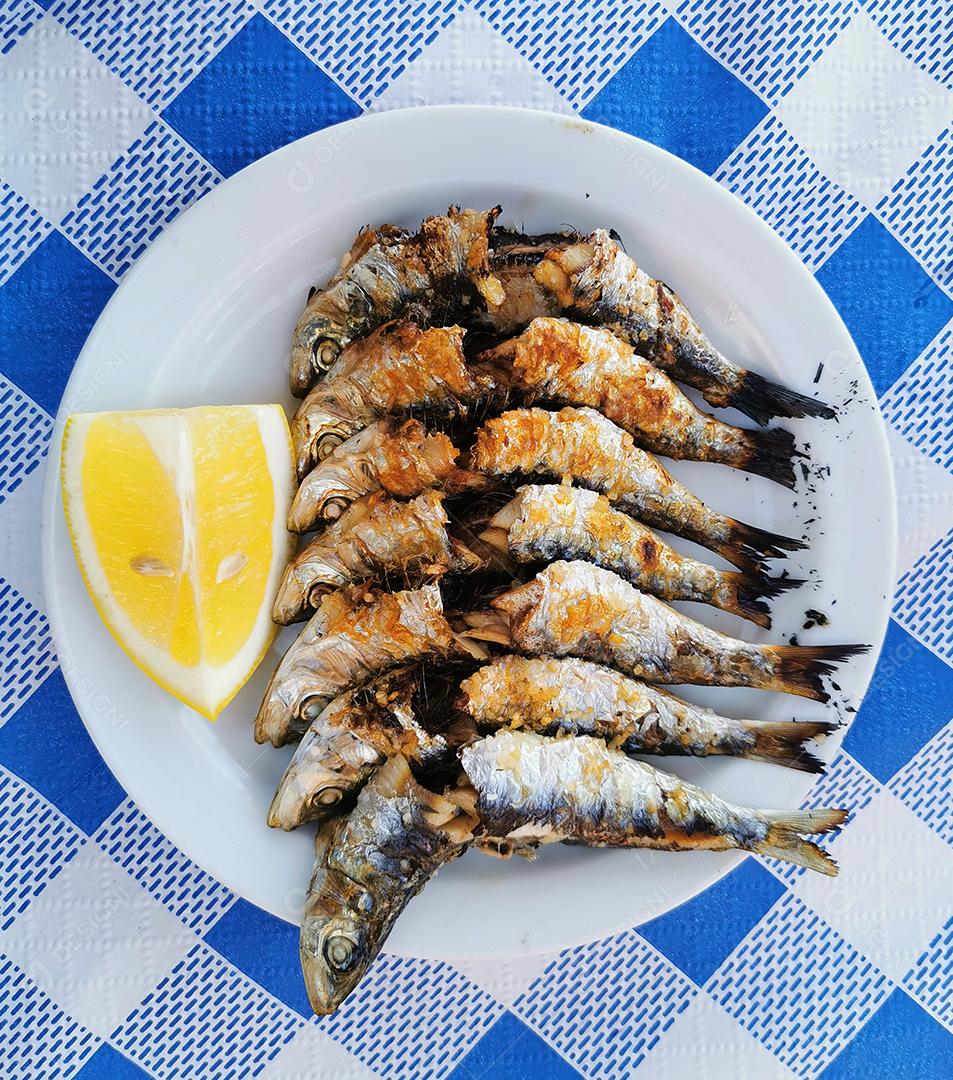 Vista de um típico espeto de sardinha no prato.