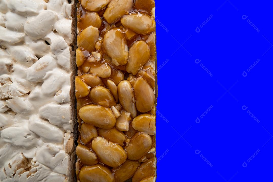 Vista superior de 2 tipos diferentes de Turrones espanhóis sobre fundo azul.