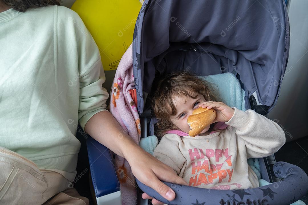 Mãe e filha se divertindo brincando com um pedaço de pão.