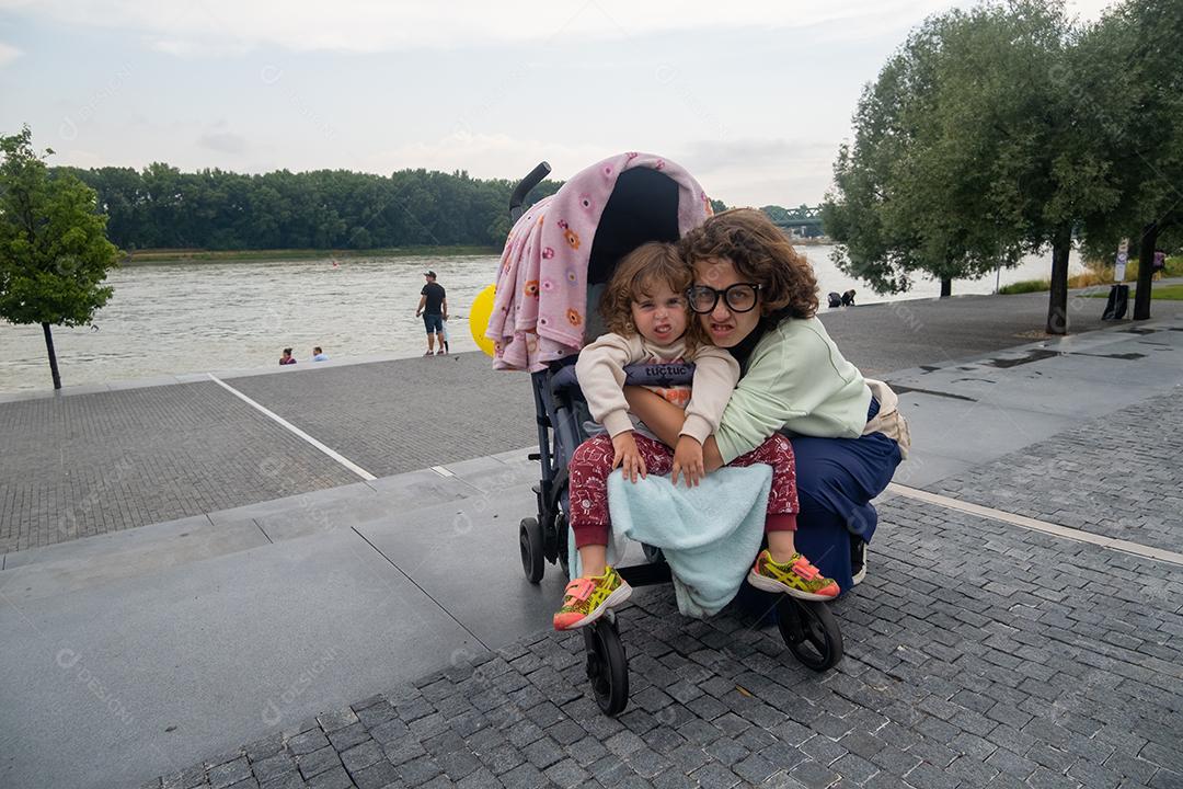 Vista de mãe e filha relaxando nas margens do rio Danúbio, na cidade de Bratislava.