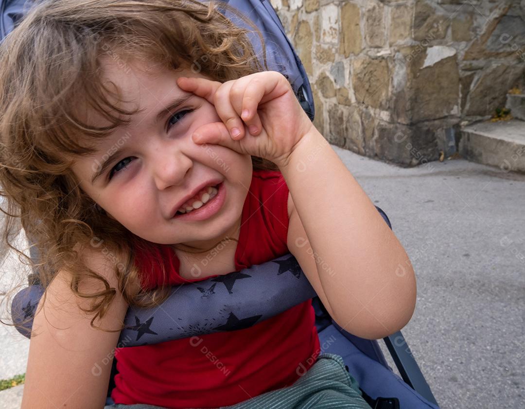 Menina sentada no carrinho fazendo poses para a câmera