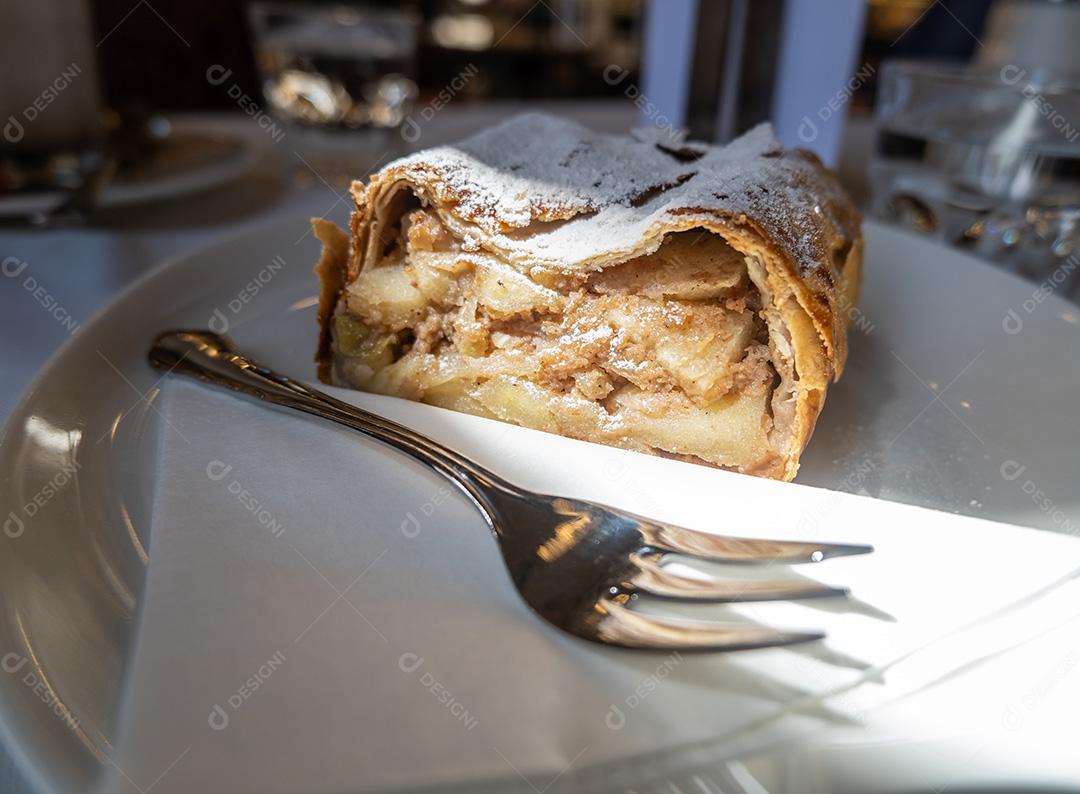 prato com pedaço de strudel de maçã e garfo, prato típico austríaco.