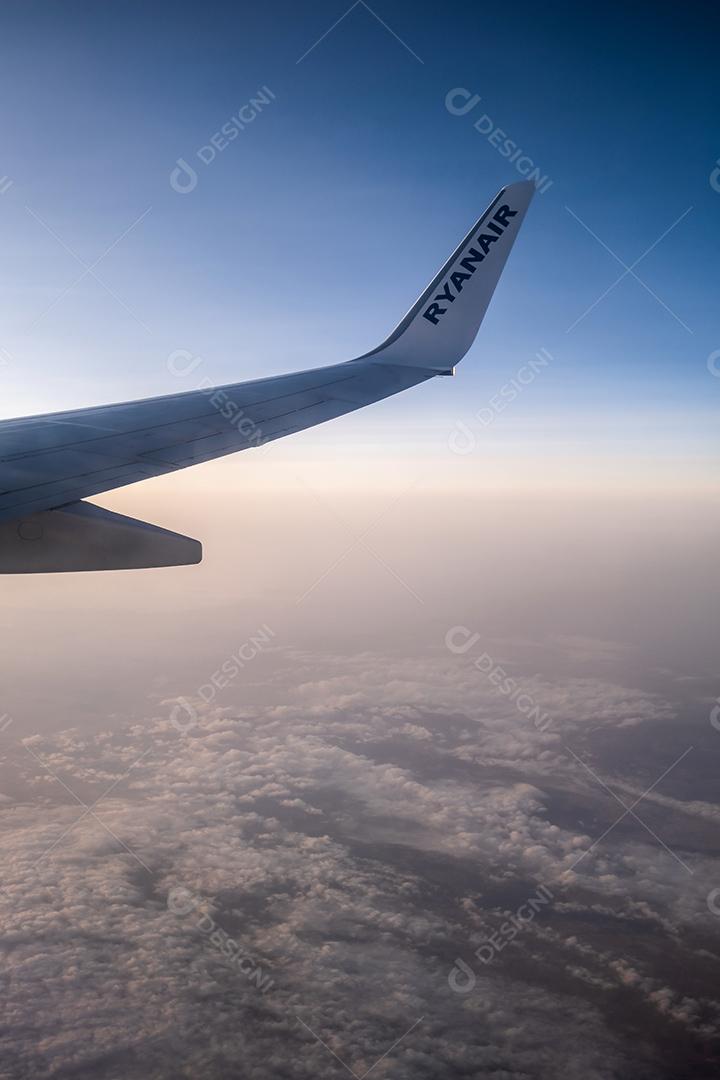 Bela vista pela janela do avião para a asa com o logotipo da Ryanair.