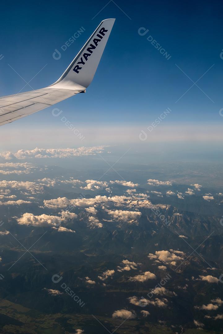 Bela vista pela janela do avião para a asa com o logotipo da Ryanair.