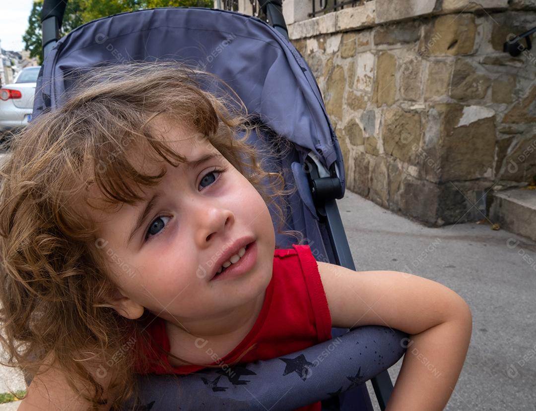 Menina sentada no carrinho fazendo poses para a câmera