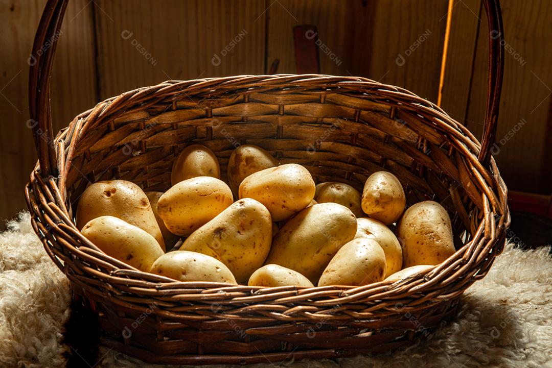 Cesta de palha com batatas em cima de um cobertor de pele de carneiro