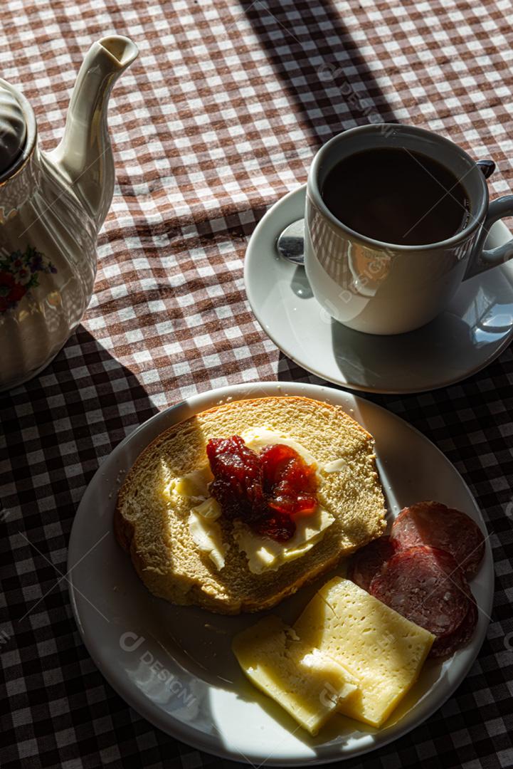 Café da manhã servido com café, pão, manteiga, geléia, queijo e sa