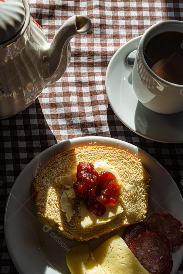 Café da manhã servido com café, pão, manteiga, geléia, queijo e sa