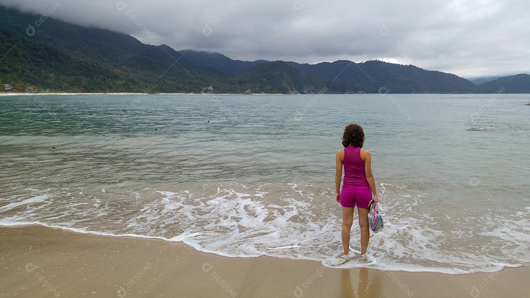 Mulher olhando a Praia do Cachadaço em Paraty, Rio de Janeiro.