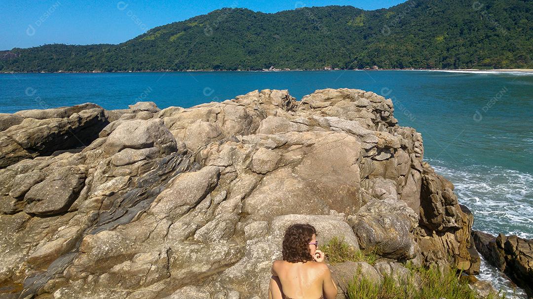 Mulher olhando a Praia do Cachadaço em Paraty, Rio de Janeiro.