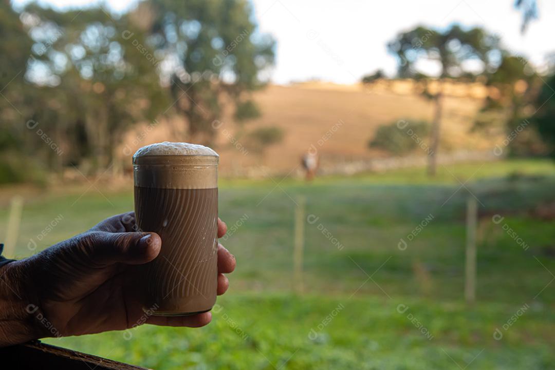 Glass of milk with coffee overlooking the farm