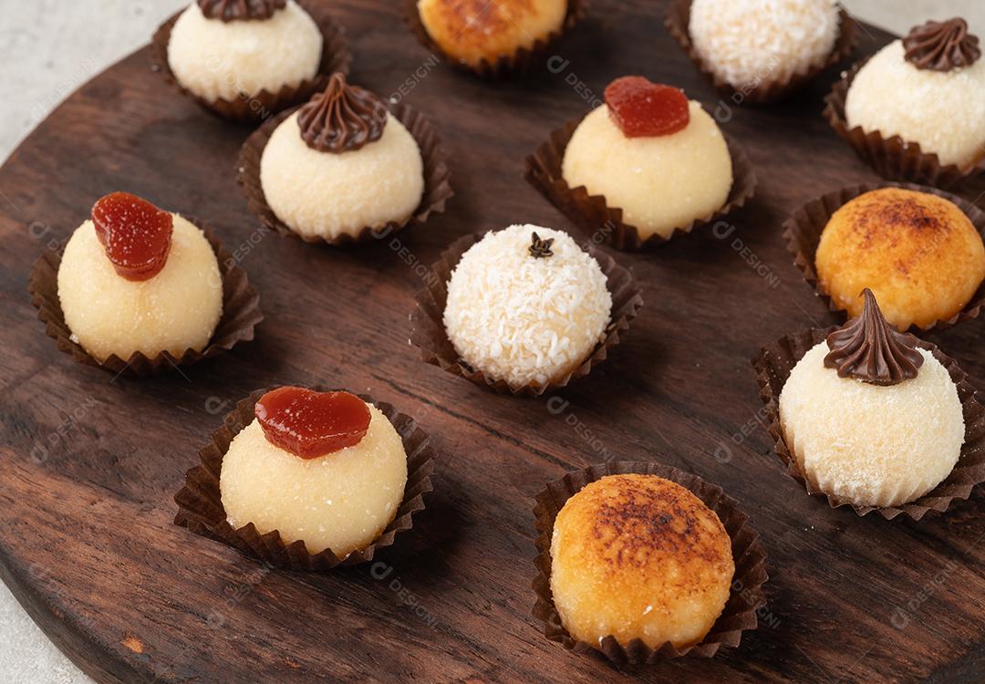 Brigadeiros gourmet típicos brasileiros, vários sabores sobre mesa de madeira.