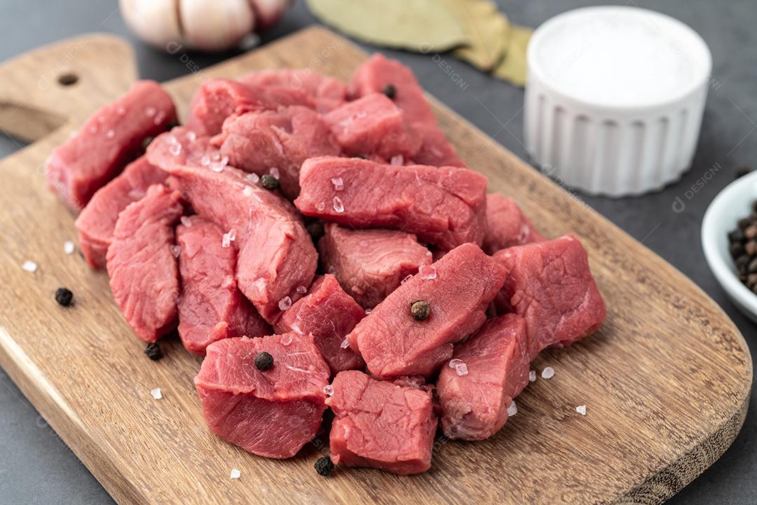 Carne topside picada em uma tigela com temperos sobre fundo de pedra