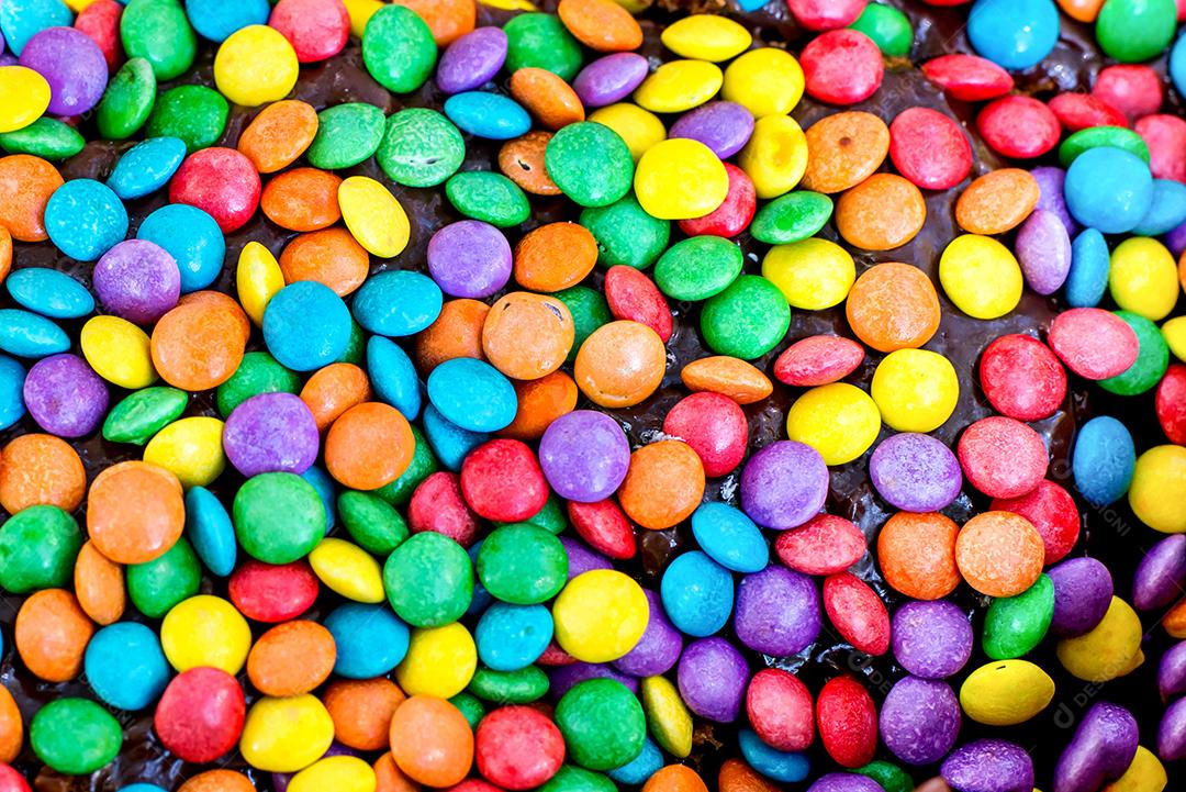 Pilha de chocolates doces coloridos confetes