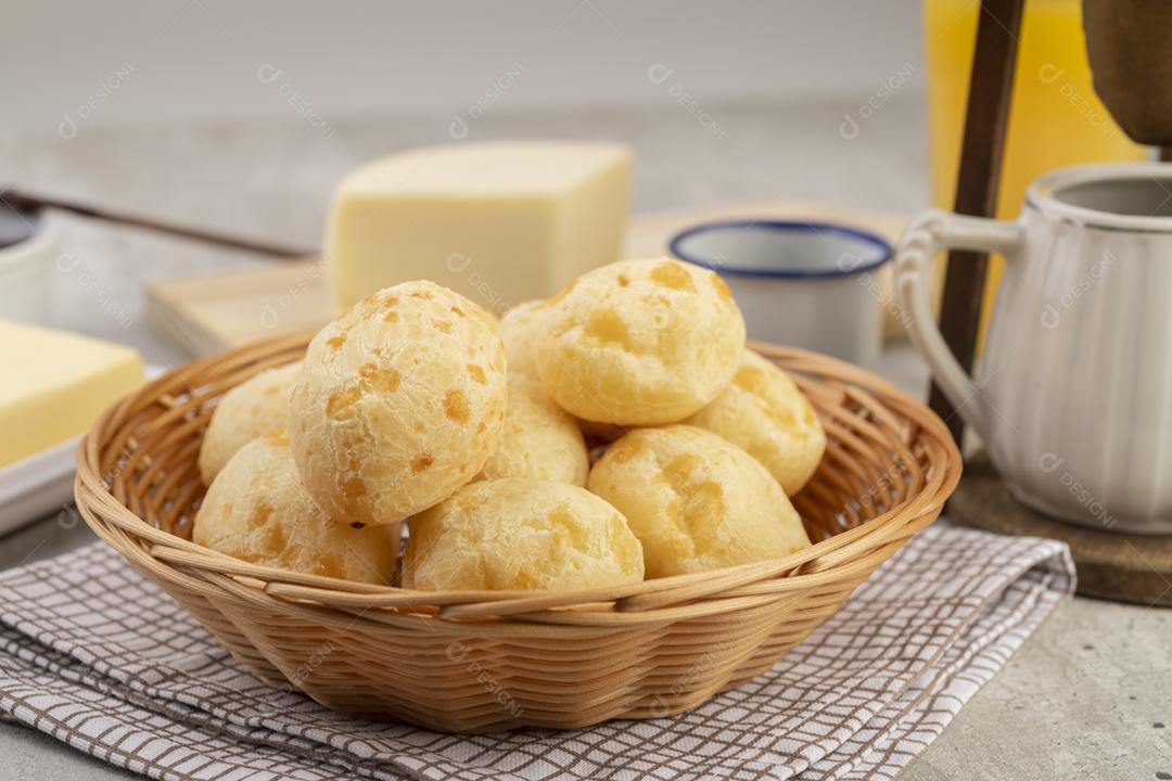 Typical Brazilian cheese bread in a bowl, coffee, butter and orange