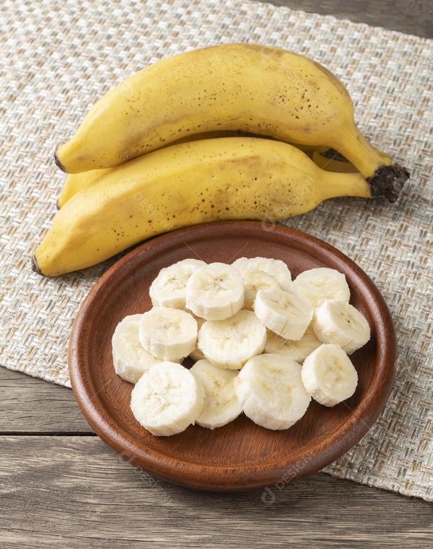 Bananas e fatias em um prato sobre a mesa de madeira