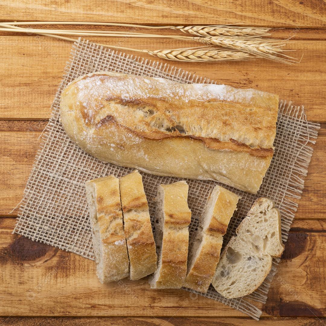 Pão de baguete francês caseiro tradicional com fatias sobre madeira