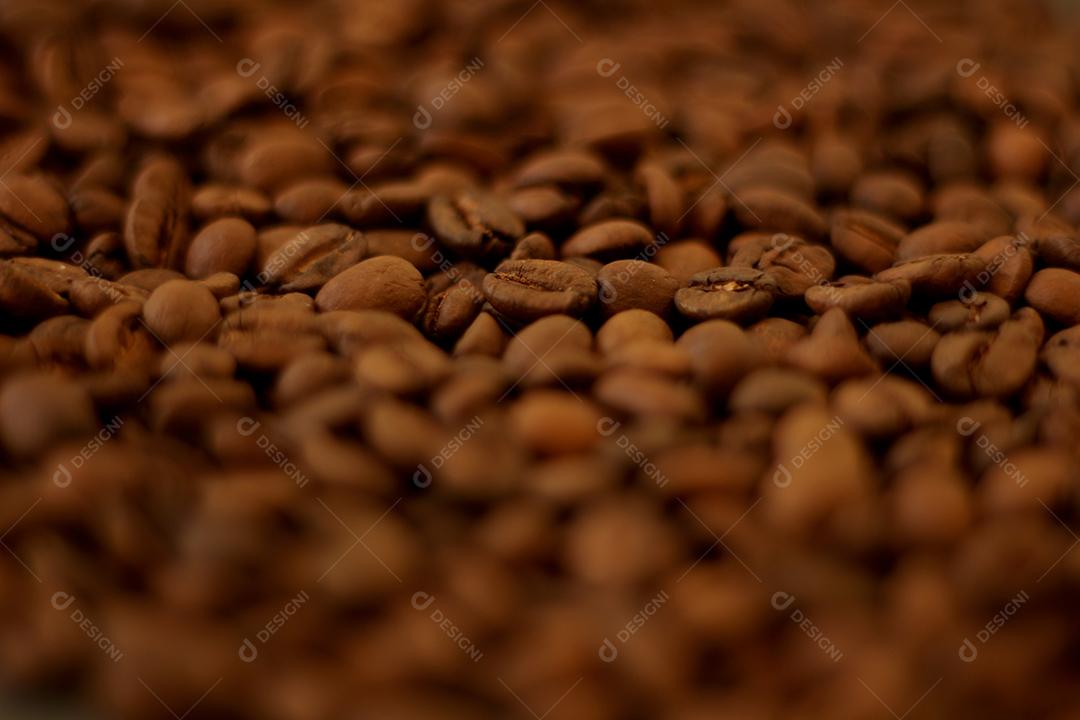 Café dentro de uma xicara sobre grãos de cafe