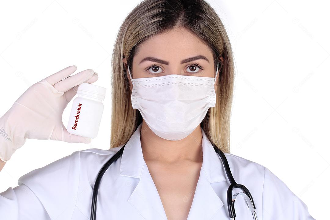 Mulher jovem segurando frasco de remedios usando mascara