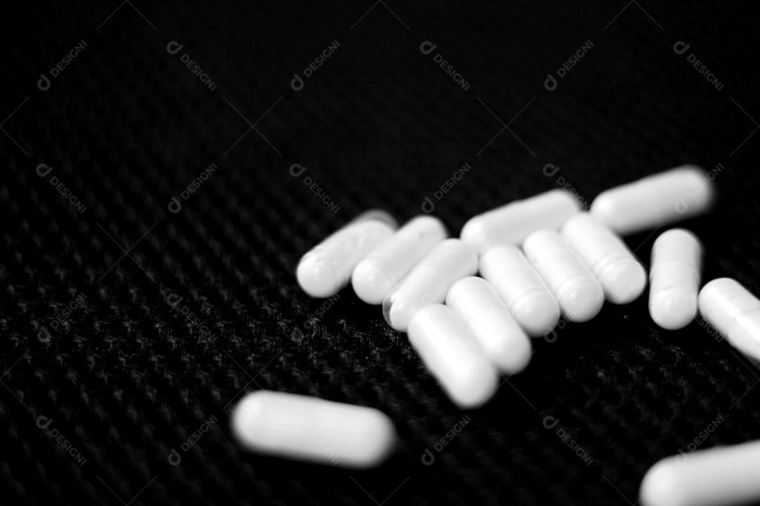 Remédio capsula sobre fundo preto