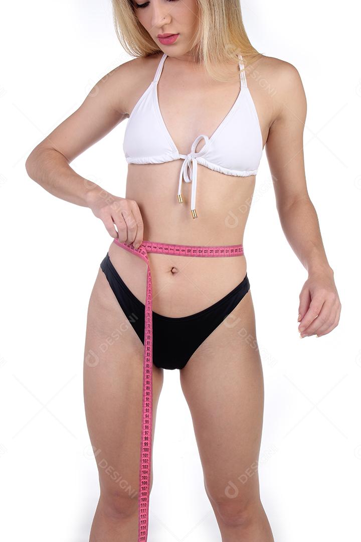 Mulher loira de biquini medindo sua barriga