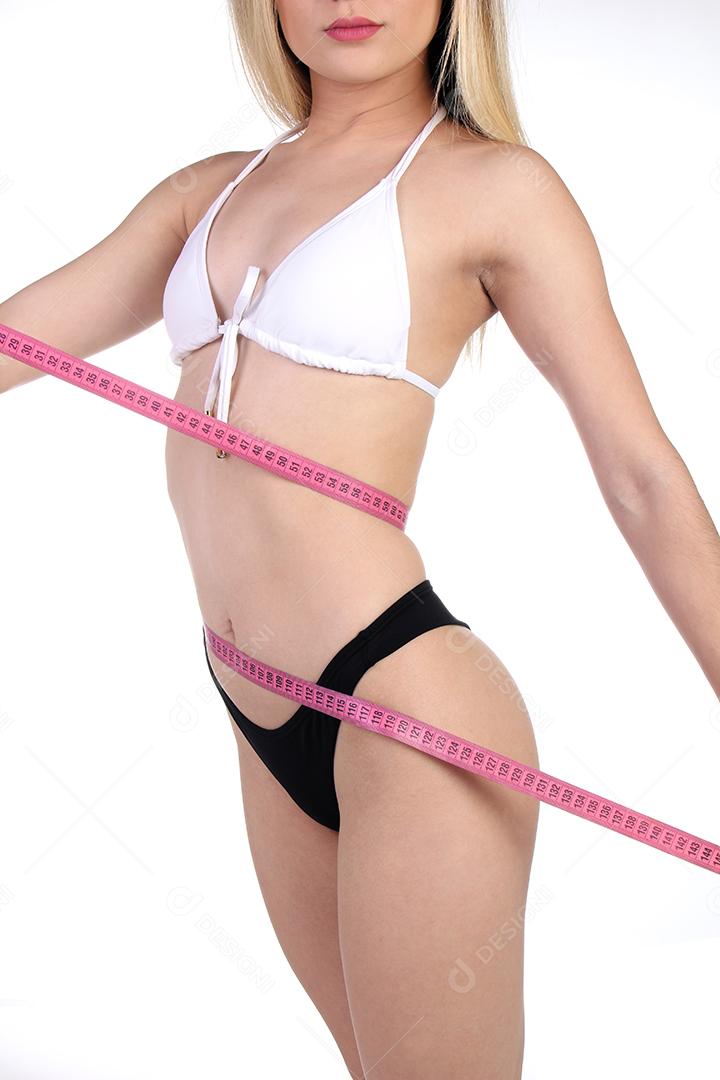 Mulher loira de biquini medindo sua barriga