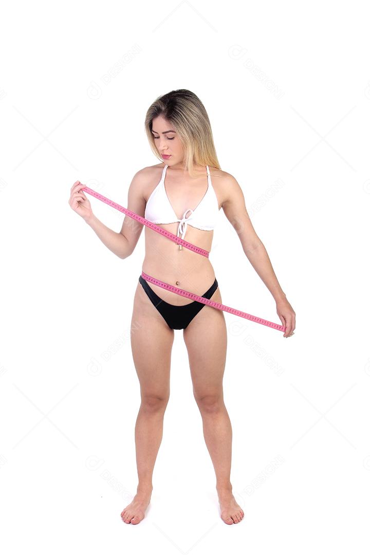 Mulher loira de biquini medindo sua barriga