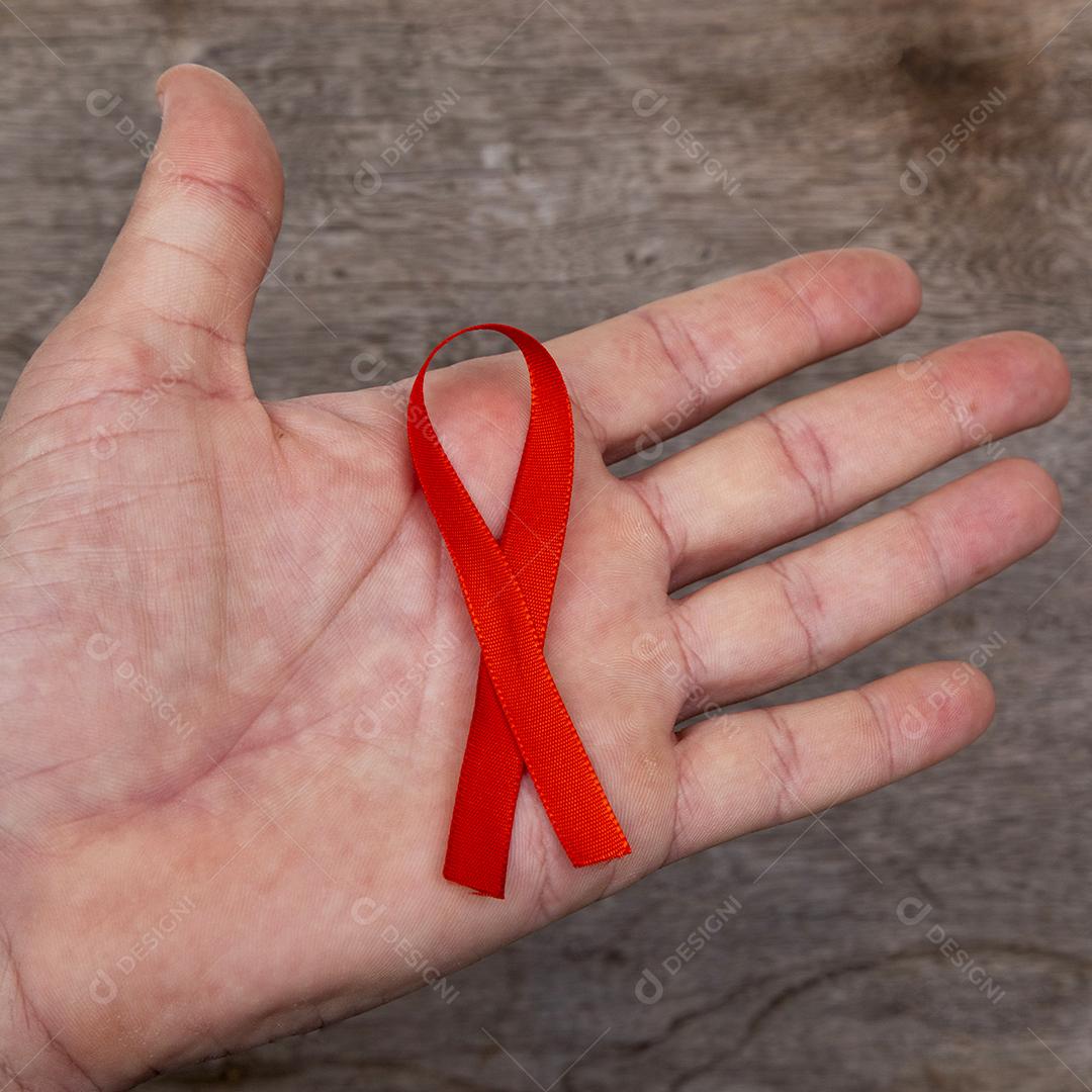 Mãos de pessoas segurando laços vermelhos