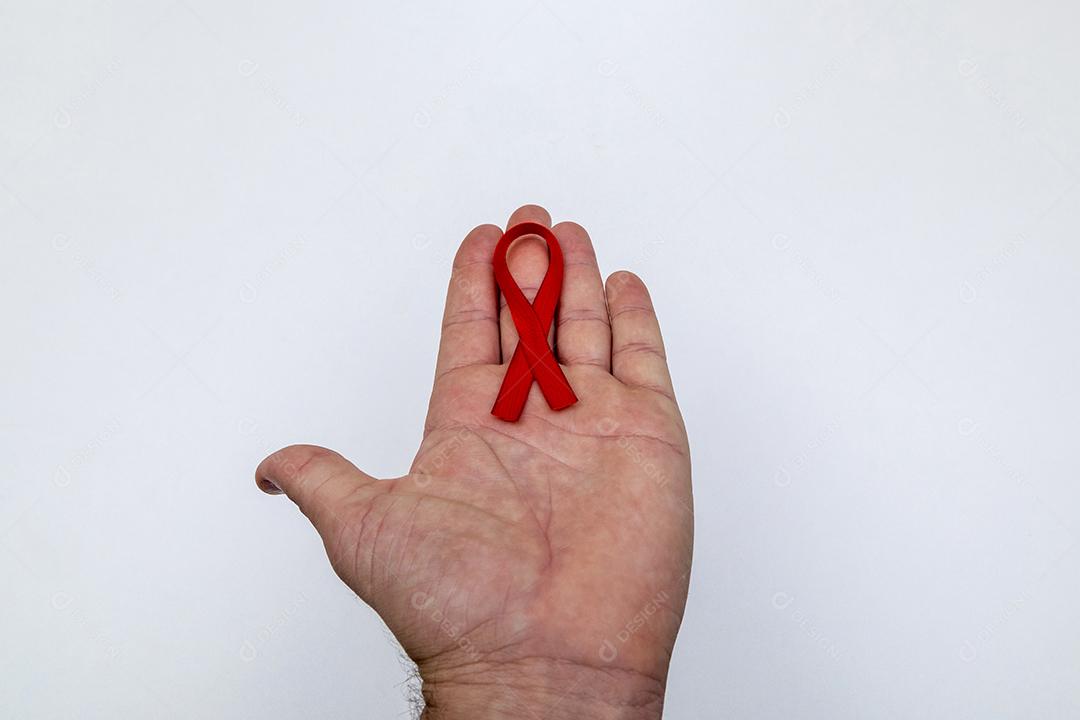 Mãos de pessoas segurando Laço vermelho sobre uma mesa branca