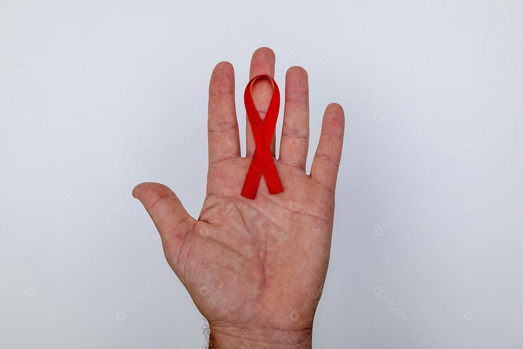 Mãos de pessoas segurando Laço vermelho sobre uma mesa branca