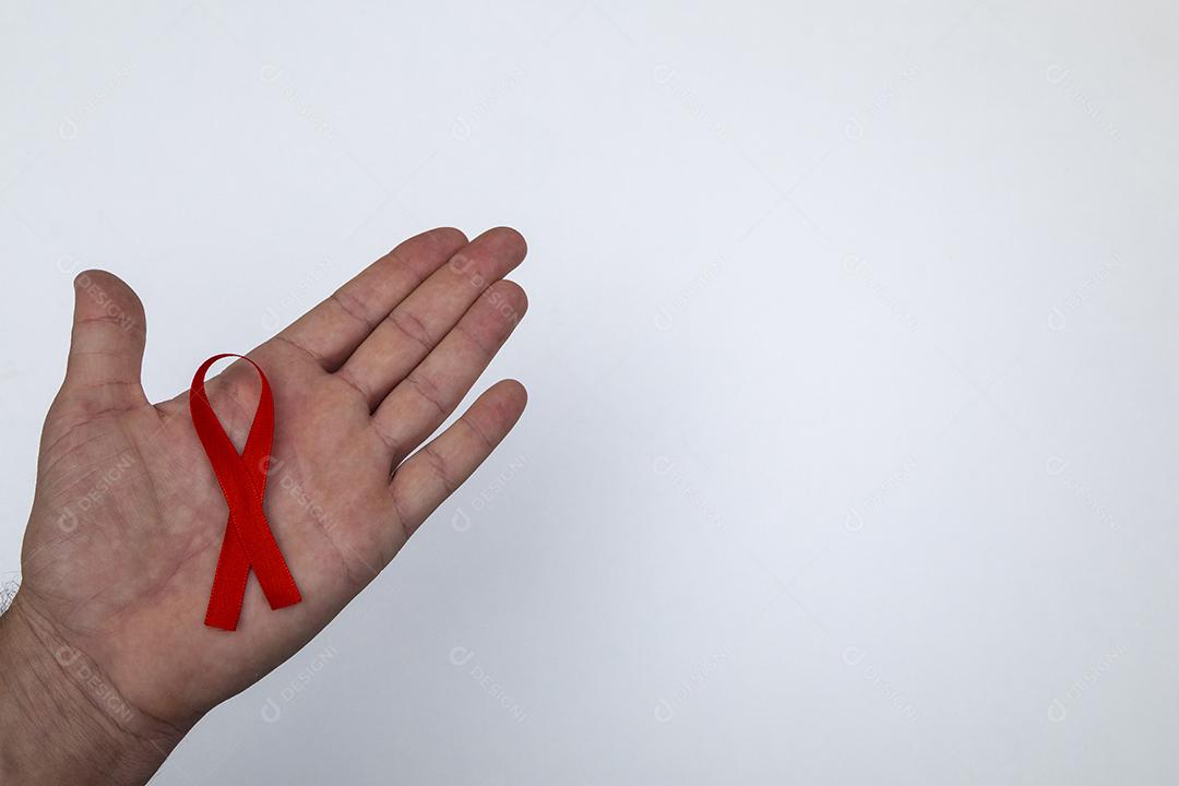 Mãos de pessoas segurando Laço vermelho sobre uma mesa branca