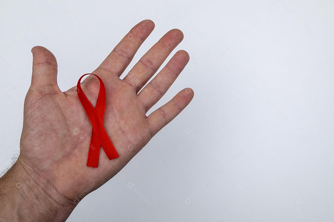 Mãos de pessoas segurando Laço vermelho sobre uma mesa branca