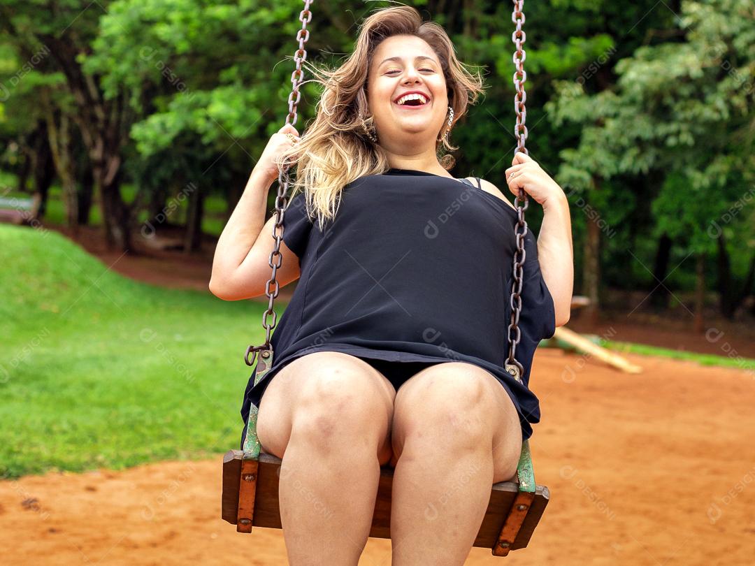 Mulher linda jovem sendo fotografada sobre campo balanço parque