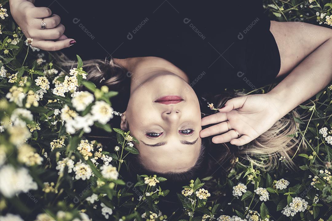 Mulher linda sorrindo sobre flores plantas