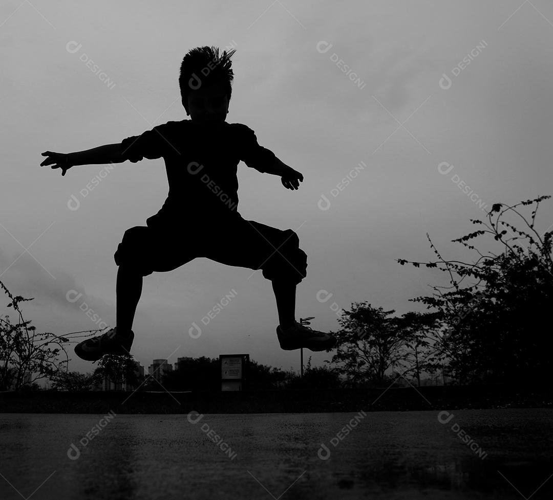 Criança feliz pulando sobre rio floresta