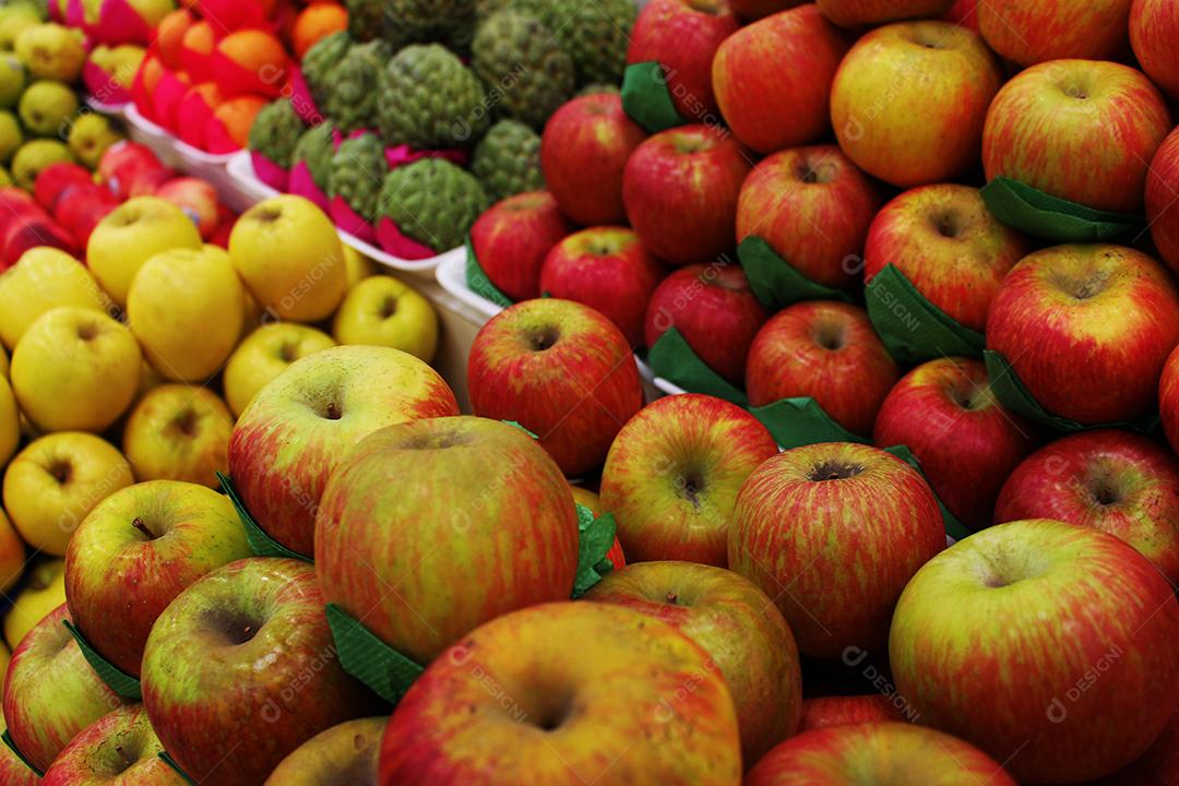 Frutas comida maçãs sobre pratileiras de mercado prontas para a vendas