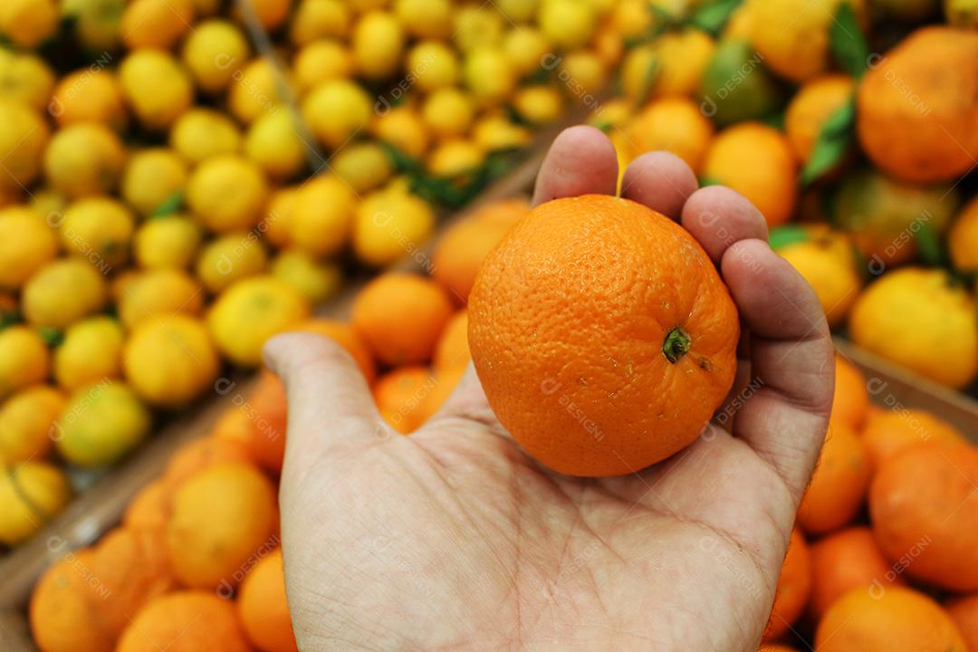 Mãos de pessoas segurando Frutas comida laranja empilhados mercado